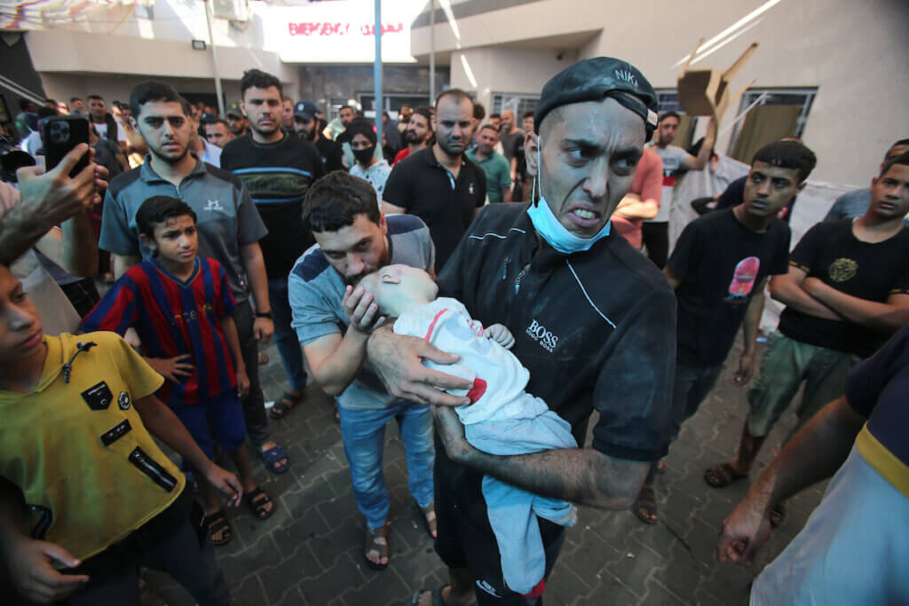 A man rushes with a baby in his arms into Al-Shifa hospital following the Israeli bombardment which hit a home in Gaza City's Mansura neighbourhood, in the eastern suburb of Shujaiya on November 4, 2023. (Photo: Bashar Taleb/APA Images)