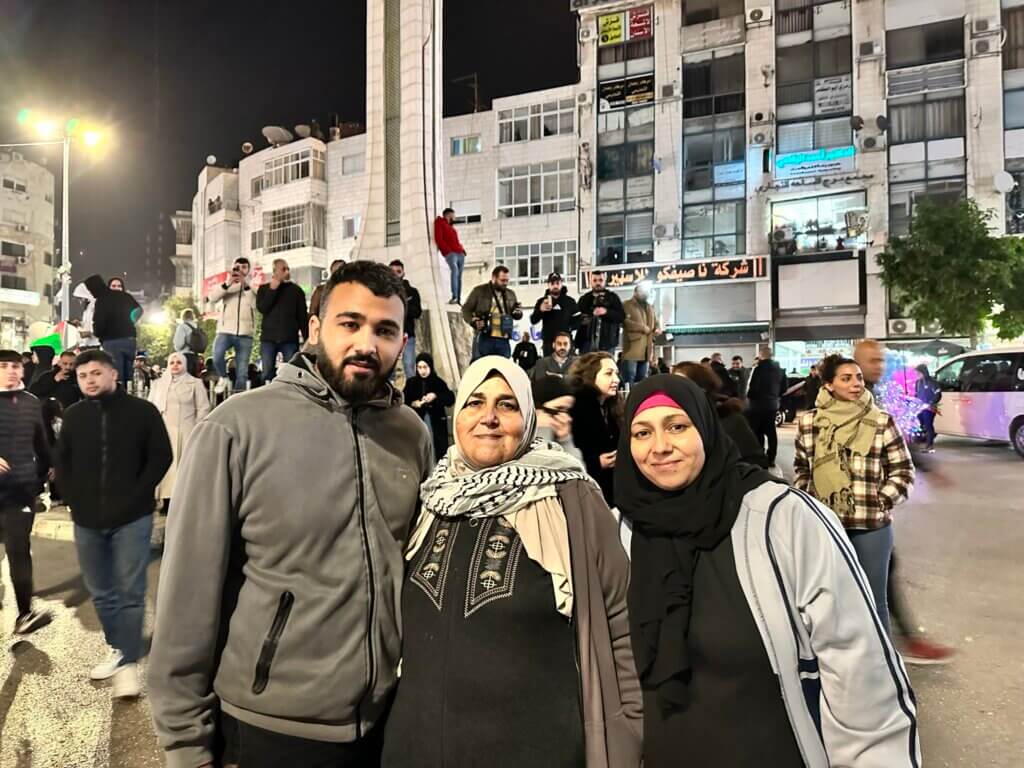 The mother of 17-year-old Ahmad Qadri Shiyha, standing between her two other children as they wait for Shiyha to to be released from Israeli prison as part of the temporary truce between Hamas and Israel. (Photo: Leila Warah)