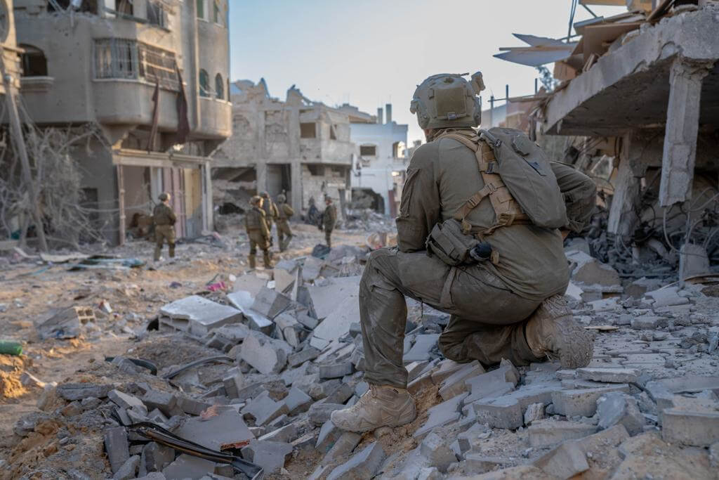 Israeli troops conducting ground operations, as a soldier kneels down on top a pile of rubble, in the northern Gaza Strip, November 10, 2023. (Photo: © Chen Junqing/Xinhua via ZUMA Press/APA Images)