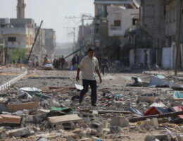 A Palestinian man inspects the damage along a neighborhood block in the southern Gaza Strip district of Khan Younis