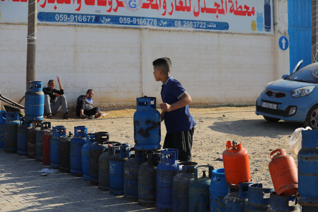 A Palestinian boy lines up empty fuel tanks in the southern Gaza Strip as Gazans anxiously await the entry of fuel into the Strip as part of a 4-day temporary "truce"and pause in Israeli bombardment. 