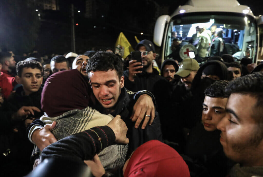 A tearful Palestinian boy hugs his friends and family after being released from Israeli prison in the Israel-Hamas hostage exchange agreement.