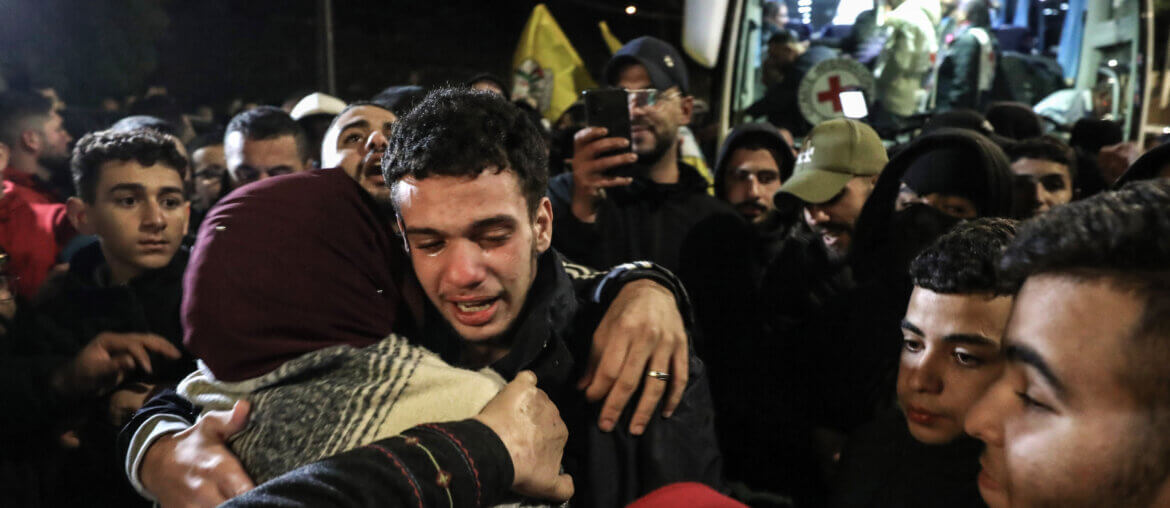 A tearful Palestinian boy hugs his friends and family after being released from Israeli prison in the Israel-Hamas hostage exchange agreement.