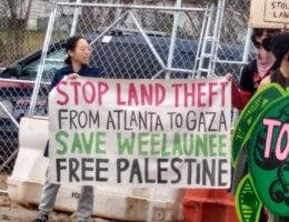 Activists hold sign at a Stop Cop City protest in Atlanta, GA drawing the connection between the land theft of the Weelaunee forest and in Palestine, November 17, 2023. (Photo: Twitter/RootsAction)