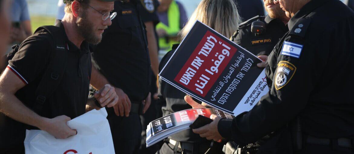 Police checking the content of banners at the entrance to an anti-war demonstration in Tel Aviv, November 18, 2023. (Photo: Oren Ziv)