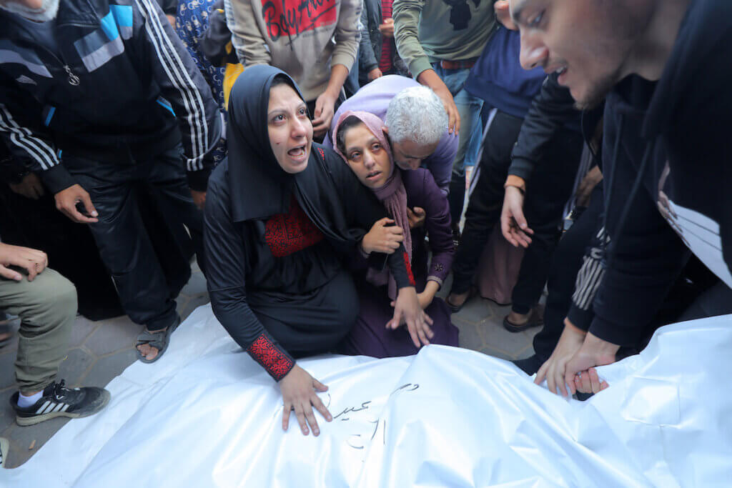 People mourn as they collect the bodies of Palestinians killed in an airstrike on December 4, 2023 in Deir al-Balah. (Photo: Omar Ashtawy/APA Images)