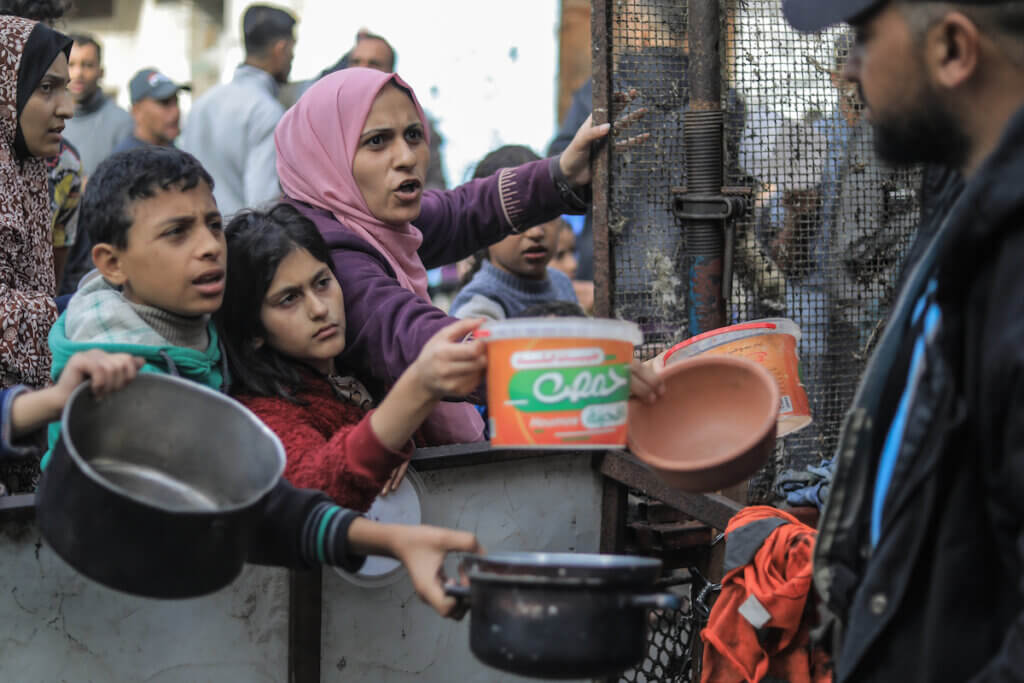 Palestinians gather to collect food cooked by volunteers for people who evacuated from Khan Younis to Rafah as a result of Israeli bombardment. (Photo: © Mohammed Talatene/dpa via ZUMA Press APAimages)