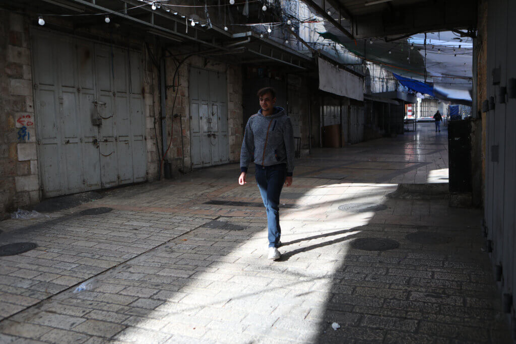 A Palestinian man walks along a deserted street in the occupied West Bank city of Nablus. The city joined other Palestinian and world cities in a global day of strike for Palestine. (APA Images)