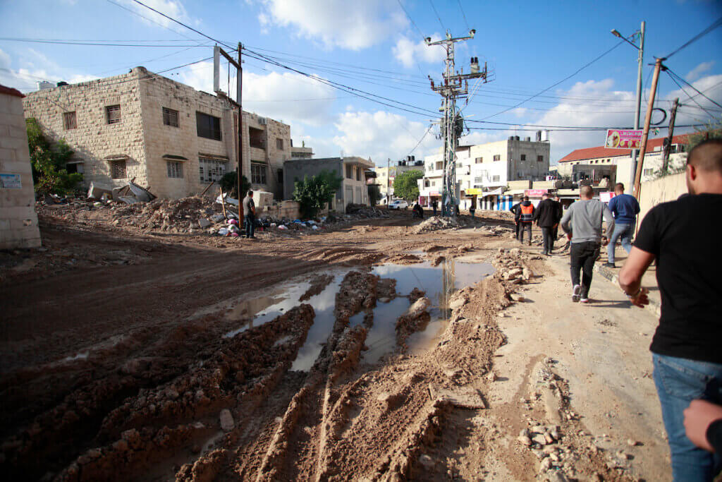 Palestinians walk through Jenin refugee camp in the aftermath of the Israeli three-day raid on the camp, December 14, 2023. (Photo: Mohammed Nasser/APA Images)