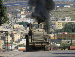 An Israeli military armored vehicle blocks a road leading to al-Faraa camp for Palestinian refugees near Tubas, during a raid at the camp in the occupied West Bank on December 18, 2023. Israeli forces have been escalating attacks across the West Bank as the world's eyes remain on Gaza. (Photo: Mohammed Nasser / APA Images)