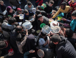 Palestinians gather with pots to receive food at a donation point provided by a charitable organization in Rafah in the southern Gaza Strip, on December 19, 2023. (Photo: Bashar Taleb/APA Images)