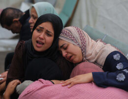 Two Palestinian women embrace as they cry and mourn the loss of loved ones killed by Israel in the al-Maghazi refugee camp in the central Gaza Strip
