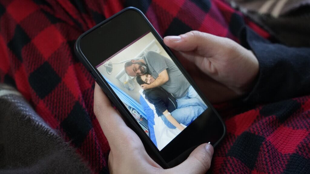 Yumna Amira looks at photos of her and her father after he was brutally arrested from her home that night. (Photo: Laila Warah)