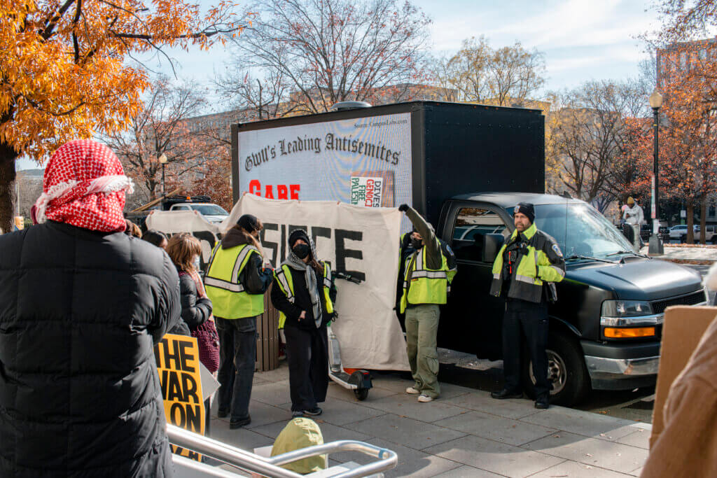 Demonstrators block the name and face of one of several students being doxxed as "GWU'S Leading Antisemites" on a truck paid for by far-right outler, Accuracy in Media on Nov. 29. (Photo: Taytum Wymer)