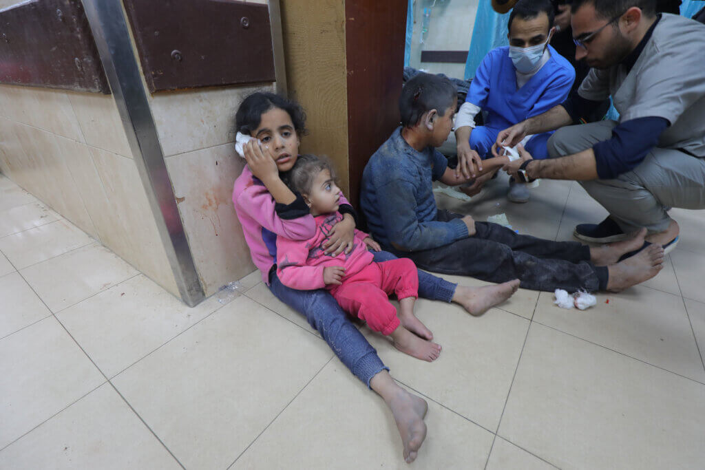Two Palestinian girls sit on the floor of a hospital in central Gaza