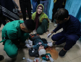 A Palestinian child istreated on the floor of a hospital after being injured in an Israeli airstrike in Gaza (APA Images)