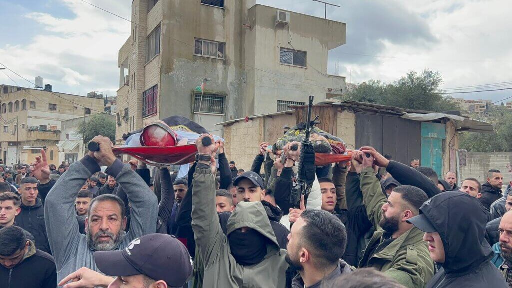 Palestinian mourners carry the bodies of two of the Palestinians who were assassinated by Israeli forces during an undercover raid on a Jenin hospital