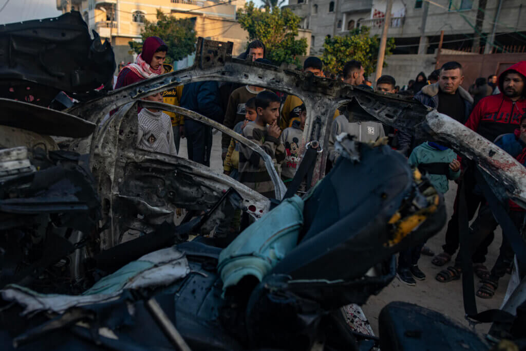 Palestinians inspect a bombed out vehicle that was targeted in an Israeli attack in Rafah in southern Gaza.