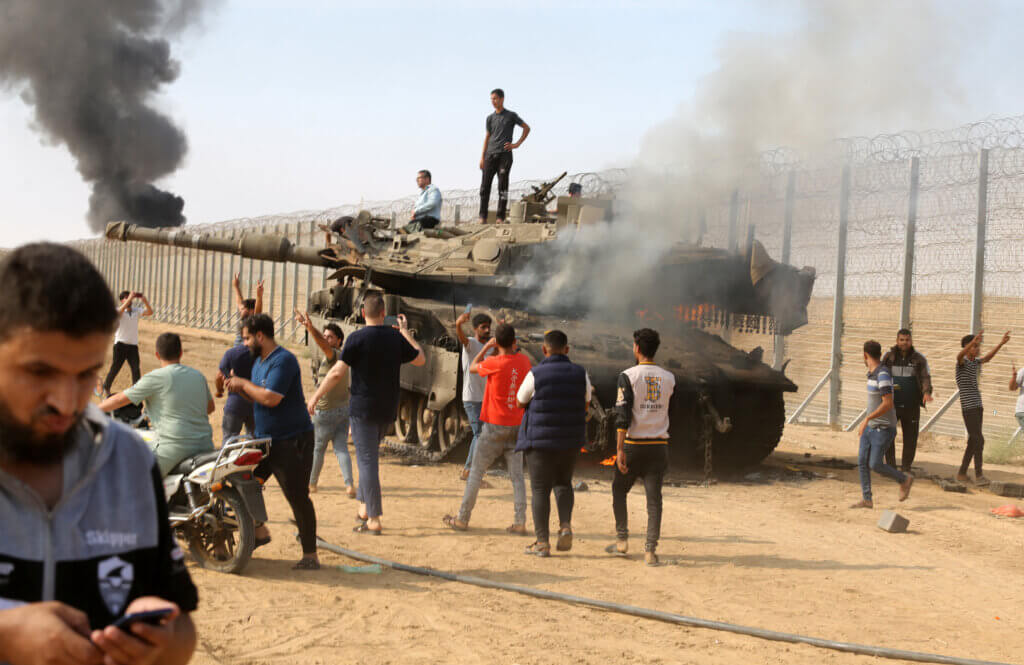 Palestinians take control of an Israeli tank after crossing the border fence with Israel from Khan Yunis in the southern Gaza Strip on October 7, 2023. (Photo: STR/APA Images)