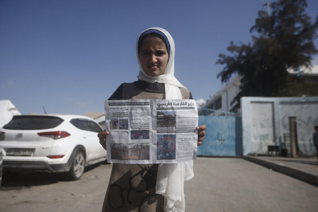 A Palestinian girl holds a warning leaflet that was dropped by Israeli forces over Rafah in the southern Gaza Strip on February 10, 2024. (Photo by Bashar Taleb/APA Images)