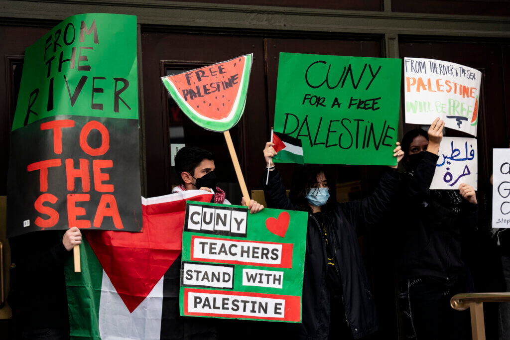 Protesters holding a sign that says, 'CUNY teachers stand with Palestine.'