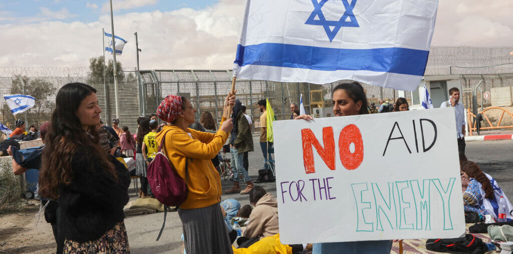Israeli demonstrators gather by the border fence with Egypt at the Nitzana border crossing in southern Israel on February 18, 2024, as they attempt to block humanitarian aid trucks from entering into Israel on their way to the Gaza Strip. (Photo: GIL COHEN-MAGEN/AFP via Getty Images)