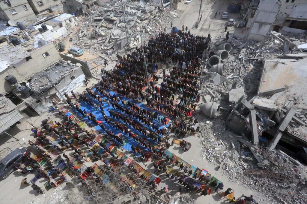 Palestinians attend the Friday noon prayers in front of the ruins of the al-Faruq mosque, destroyed in Israeli strikes on Rafah in the southern Gaza Strip on March 1, 2024. (Photo: Stringer/APA Images)