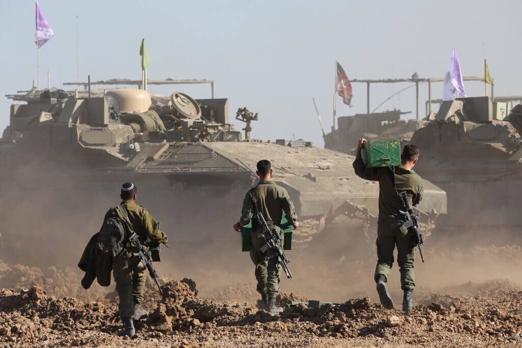 Israeli soldiers walk toward military vehicles in the Gaza Strip, March 10, 2024 (Photo: © Abir Sultan/EFE via ZUMA Press APA Images)