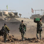 Israeli soldiers walk toward military vehicles in the Gaza Strip, March 10, 2024 (Photo: © Abir Sultan/EFE via ZUMA Press APA Images)
