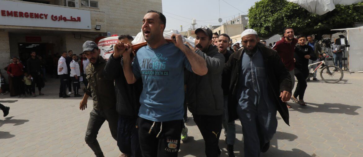 Relatives of Palestinians killed in Israeli airstrikes carry the bodies of their loves ones from the morgue at al-Aqsa Hospital for burial, Deir al-Balah, March 27, 2024. (Photo: Ali Hamad/APA Images)