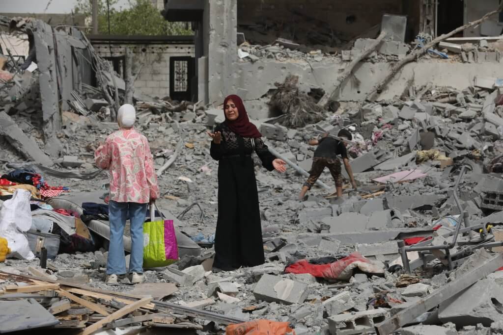 A dismayed Palestinian woman asses the damage on a street in the Nuseirat refugee camp in the central Gaza Strip following the Israeli military's withdrawal from the area.
