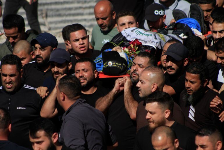 Mourners carry the bodies of Palestinian men killed in an Israeli raid in the Nur Shams camp during their funeral procession in the occupied West Bank city of Tulkarem, on April 21, 2024. (Photo: Mohammed Nasser/APA Images)