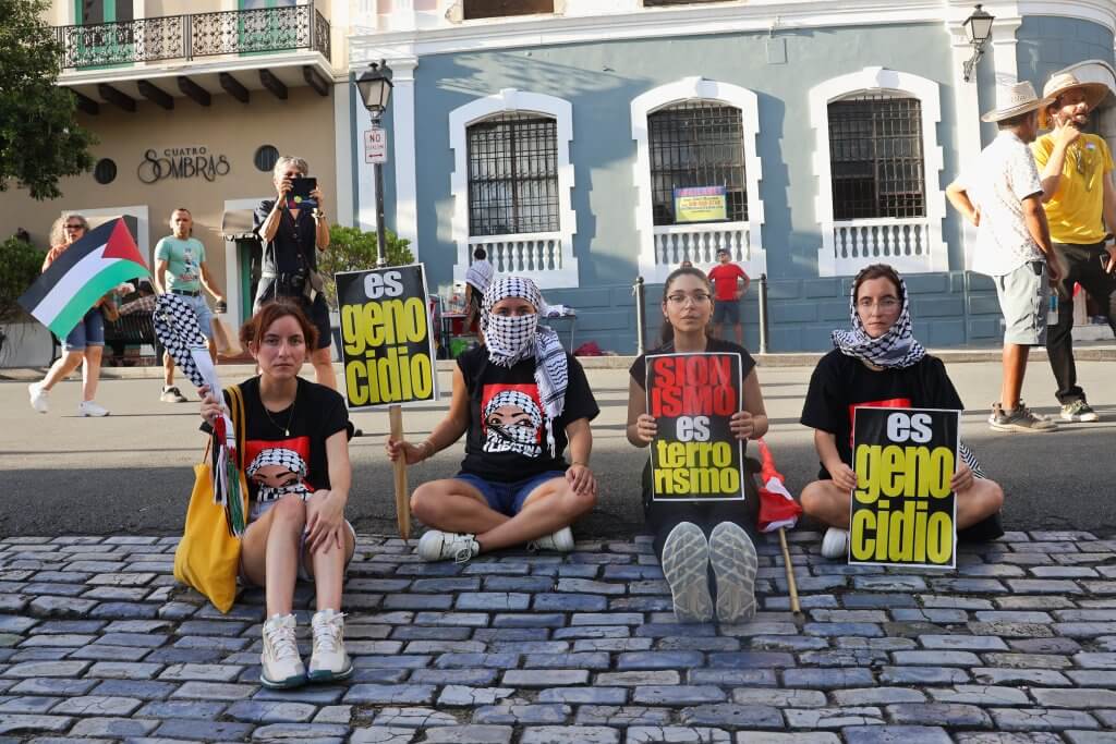Educator Natalie Santana sits beside her sisters and comrades at a solidarity march in Viejo San Juan, PR on Nov. 12 2023.