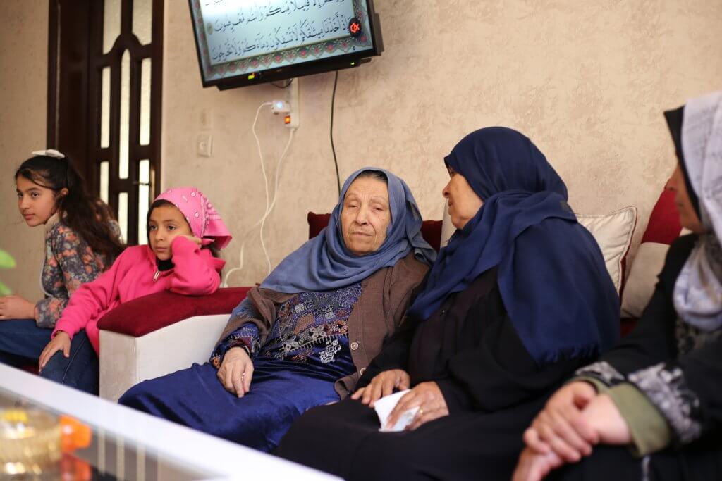Amira Hajjaj, 72, (center), at her home with relatives in al-Shuja'iyya in 2022. (Photo: Tareq Hajjaj)