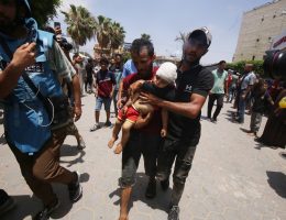 An Injured Palestinian child is carried into the Al-Aqsa Martyrs Hospital in Central Gaza.