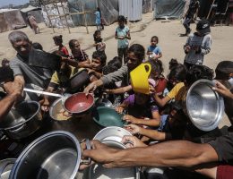 Displaced Palestinians, including children, receive a hot meal distributed by an aid organization in Zawaida, June 27, 2024. (Photo: Omar Ashtawy/APA Images)