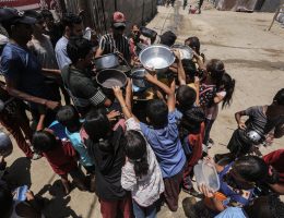 Displaced Palestinians, including children, receive a hot meal distributed by an aid organization in Zawaida, June 27, 2024. (Photo: Omar Ashtawy/APA Images)