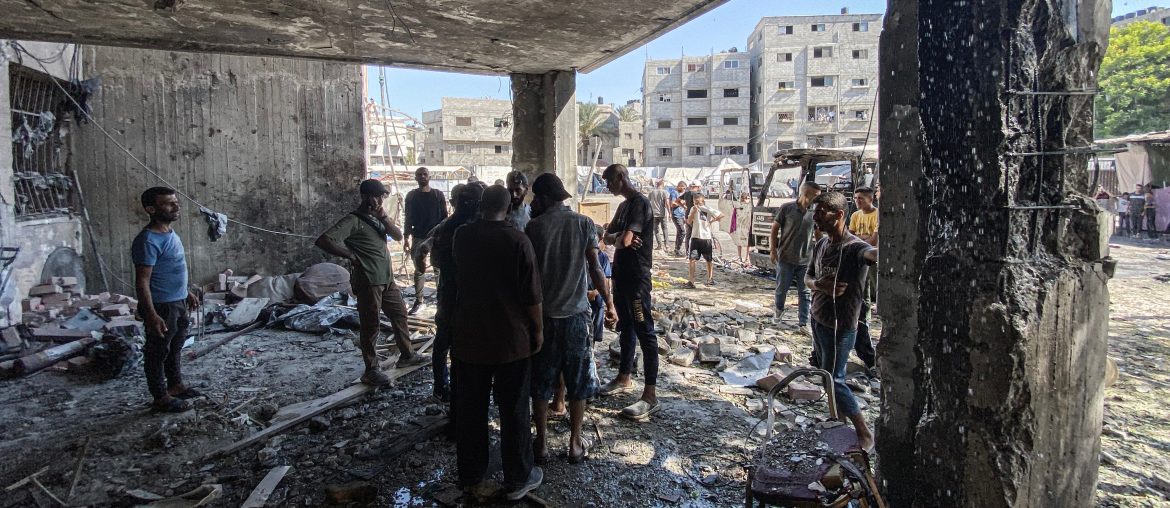 A group of people inspect the damage in a bombed out room of a school that was targeted by an Israeli airstrike in Gaza.