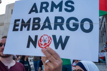 A protester holding up a sign calling for an arms embargo on Israel. (Photo: Social media)