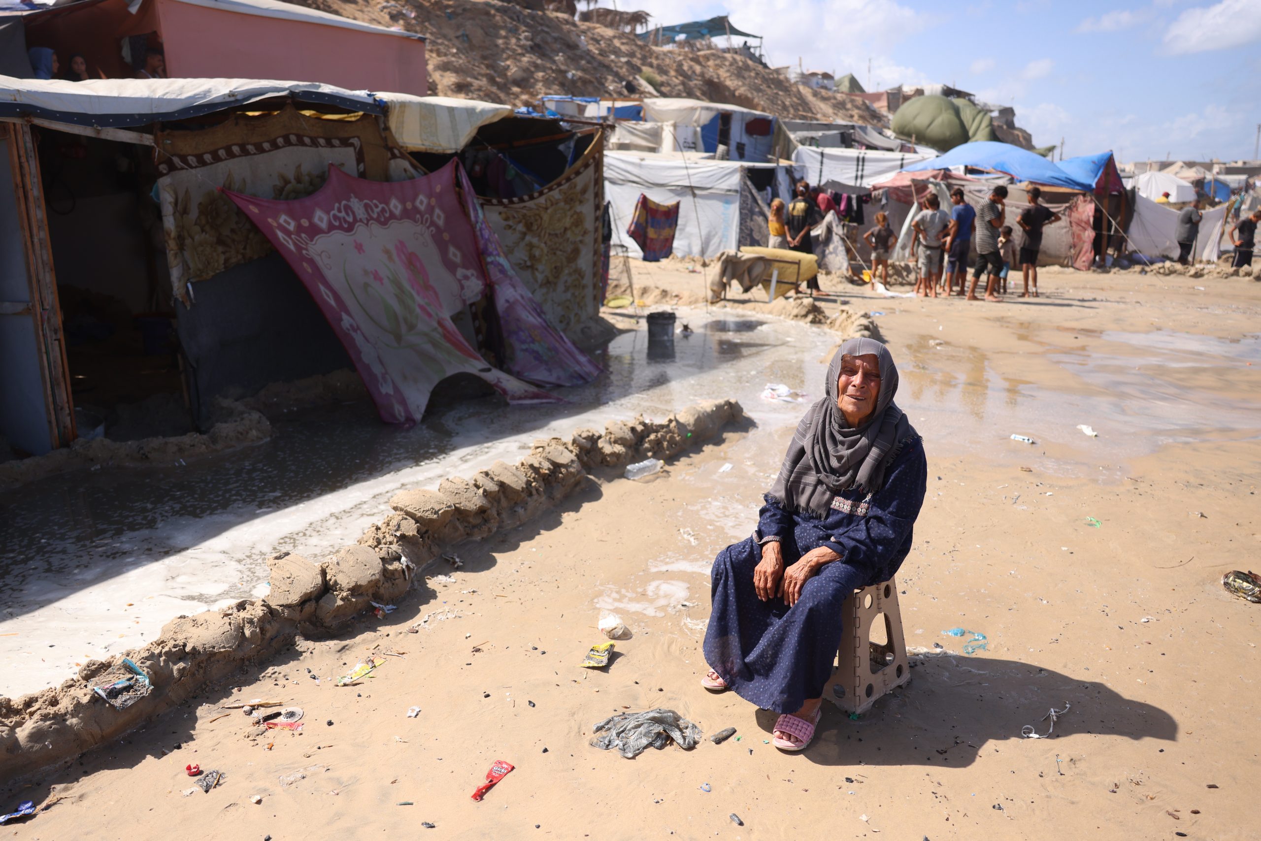 Displaced Palestinian families clear their tents of seawater after the tide damaged their encampment in Khan Younis, September 15, 2024. (Photo: Omar Ashtawy/APA Images)