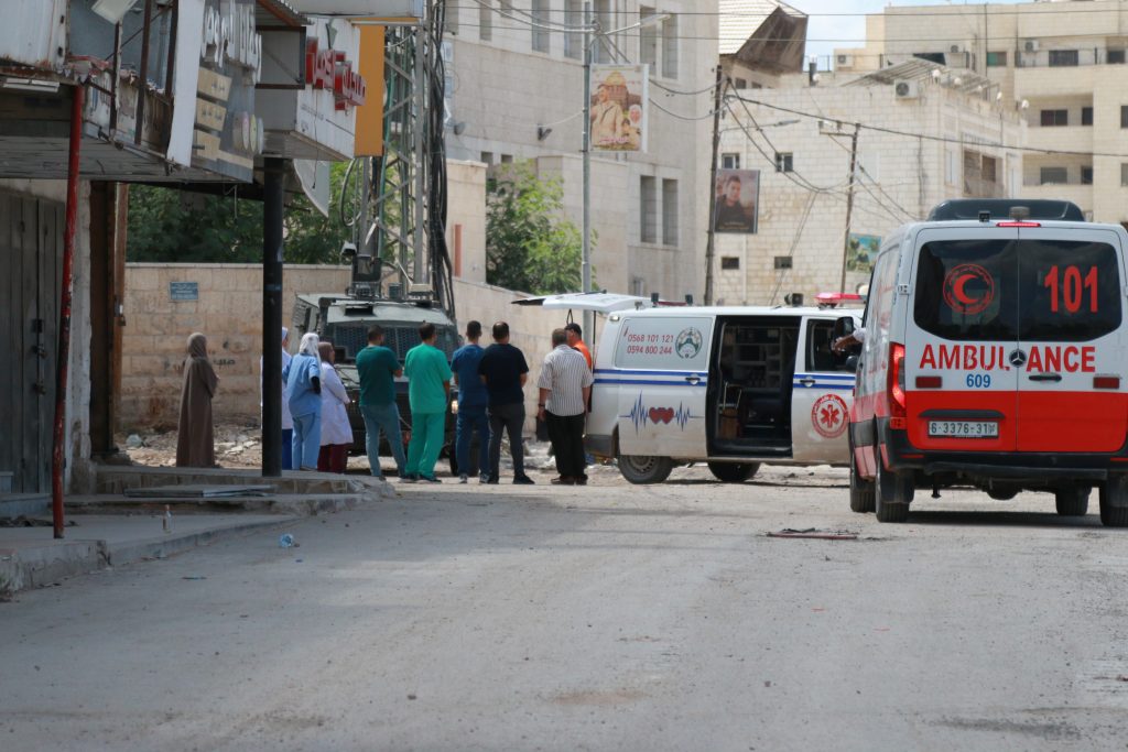 Medical personnel and ambulances are stalled by an Israeli military vehicle preventing them passage. During the attack on the city, medics say they were directly targeted by Israeli gunfire. September 3, 2024. Photo by Shatha Hanaysha.