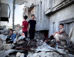 Palestinian boys sit on the rubble of a destroyed building in Gaza