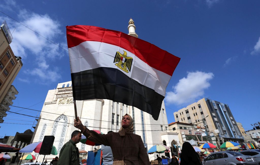 Palestinians in Gaza wave the Egyptian flag during a rally to say Gaza strip on February 13, 2021. (Photo: Ashraf Amra/APA Images)