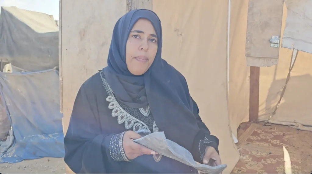 Ruwaida Abu Taima holds a piece of shrapnel form an Israeli bomb that cut through her tent in the Mawasi area of Khan Younis in the southern Gaza Strip (Photo: Hassan Suleih)