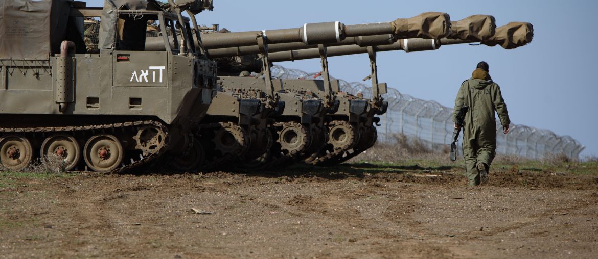 An Israeli soldier walks past M109 155mm self-propelled howitzers in the Israeli-occupied Golan Heights near the Syrian border in 2023. (Image: Ayal Margolin/Jini/Xinhua via ZUMA Press/APAIMAGES)