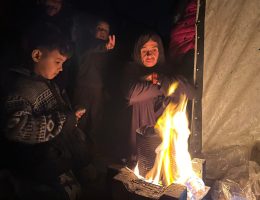 A Palestinian family warms themselves in the cold weather by lighting a fire in a tent, in Nuseirat Refugee Camp, located in the central part of the Gaza Strip, on December 27, 2024. (Photo: Saed Abu Nabhan/APA Images)