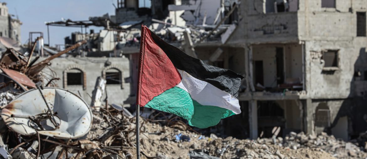 A Palestinian flag stands amid the rubble in the Gaza Strip on January 20, 2025. (Photo: Omar Ashtaw/ APA Images)