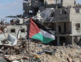 A Palestinian flag stands amidst the rubble in the Gaza Strip