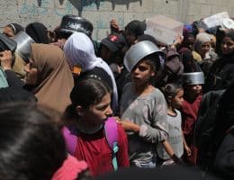 Palestinians wait in long queues to receive pots of food distributed by charitable organizations, Nuseirat refugee camp, central Gaza, May 5, 2025. (Photo: Moiz Salhi/APA Images)