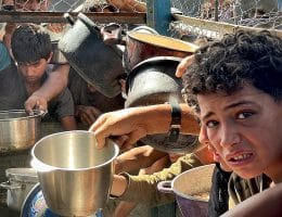Palestinians wait in long lines to receive pots of food distributed by charitable organizations, as they face food crisis, in Al-Mawasi area in Khan Yunis, Gaza strip on May 25, 2025. (Photo: Moaz Abu Taha/APA Images)